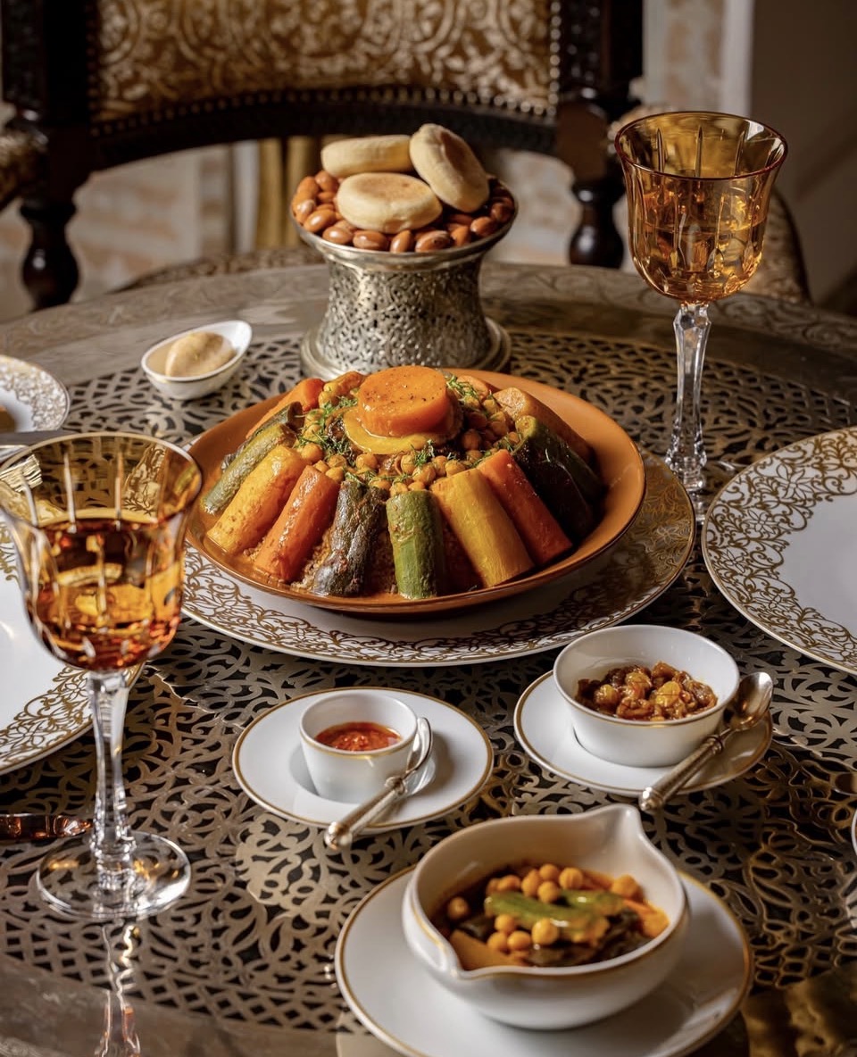 Couscous royal marocain servi sur une table dressée en argenterie et verres dorés